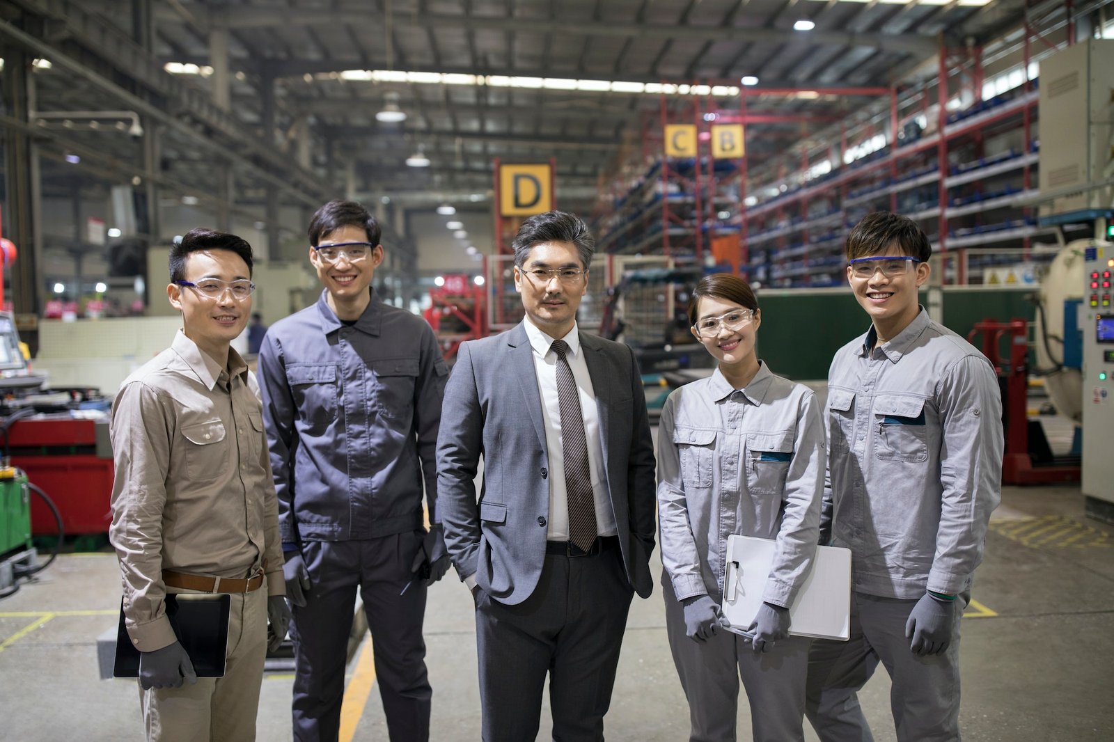 Confident businessman and engineering team in the factory